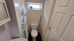 a small bathroom with a toilet and a door at Tennyson Lodge in Mablethorpe