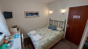 a small bedroom with a bed and a door at Tennyson Lodge in Mablethorpe