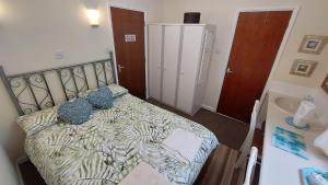 a small bedroom with a bed and a sink at Tennyson Lodge in Mablethorpe