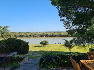 a view of a lake from a park with a bench at 10 on Aquavista Addo River View Villa in Colchester