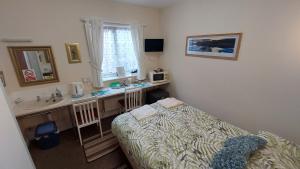 a small bedroom with a bed and a sink at Tennyson Lodge in Mablethorpe