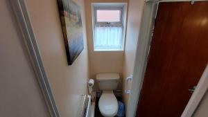 a small bathroom with a toilet and a window at Tennyson Lodge in Mablethorpe
