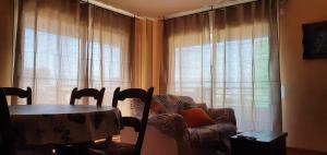 sala de estar con mesa, silla y ventana en Apartamento Tarraco, en Tarragona