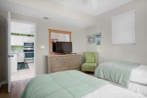 1 Schlafzimmer mit 2 Betten, einem TV und einem Stuhl in der Unterkunft Leeward Key 204 in Destin