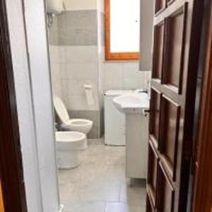 uma casa de banho com um WC e um lavatório em Appartamento em Carbonia