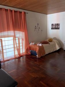 斯波萊托的住宿－Appartamento Central Palace Spoleto，一间卧室配有一张带橙色窗帘的床,铺有木地板