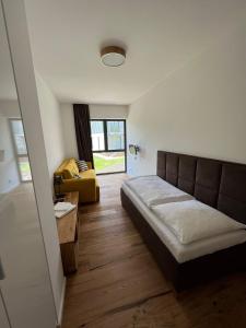 a bedroom with a bed and a yellow couch at TATRYSTAY Brezy Luxury Apartment in Stará Lesná