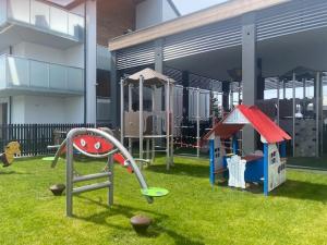 a playground with a slide and a play structure at Baltic Apartment Posesja Kapitańska in Grzybowo
