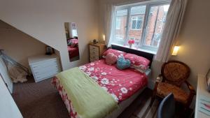 a small bedroom with a bed and a window at Tennyson Lodge in Mablethorpe