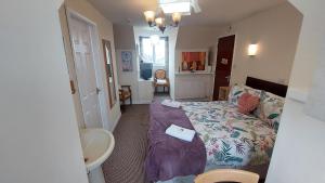 a small room with a bed and a bathroom at Tennyson Lodge in Mablethorpe