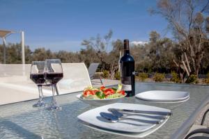 利吉亞的住宿－Naiades Villas，一张桌子,上面放着一杯葡萄酒和一碗水果