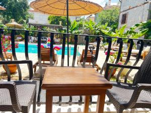 瑟利加梅的住宿－韓精品酒店，桌椅、遮阳伞和游泳池