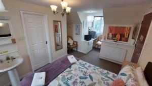a bedroom with a bed and a bathroom with a sink at Tennyson Lodge in Mablethorpe