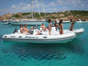 a group of people sitting on a boat in the water at Hotel Palumbalza Porto Rotondo in Porto Rotondo