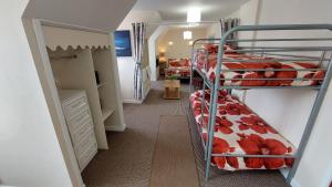 a small room with two bunk beds and a hallway at Tennyson Lodge in Mablethorpe