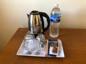 Ein Teekessel und eine Flasche Wasser auf einem Tisch in der Unterkunft Bristol Hotel in Buenos Aires