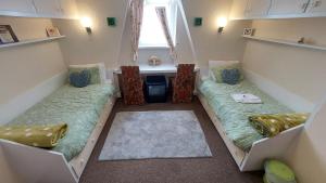 two beds in a room with a sink and a window at Tennyson Lodge in Mablethorpe