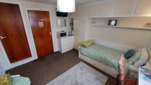 a small room with a couch and a microwave at Tennyson Lodge in Mablethorpe