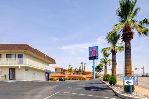 a no parking sign in a parking lot with palm trees at Motel 6 Saint George, UT in St. George