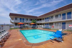 une piscine dans un hôtel avec des chaises et un hôtel dans l'établissement Motel 6 Saint George, UT, à Saint George