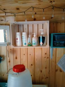 una habitación con una estantería con varias botellas de jabón en Maringotka Ivetka, en Luže