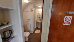 a small bathroom with a toilet and a sink at Tennyson Lodge in Mablethorpe