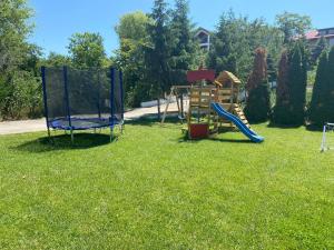 un parque infantil en un patio con tobogán en Pensiunea Știuca Șchioapă, en Carasuhatul-de-Sus