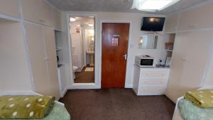 a room with a hallway with a door and a kitchen at Tennyson Lodge in Mablethorpe