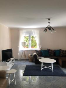 a living room with a couch and tables and a tv at Dom Sówka in Radzyń