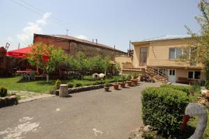 a yard with a house and a patio with plants at Mardoyan's Guest house in Gavarr
