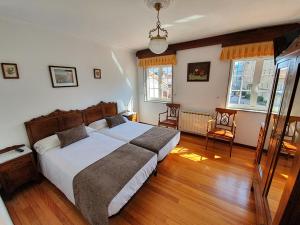 1 dormitorio con 1 cama grande y suelo de madera en Hostal Giadás, en Santiago de Compostela
