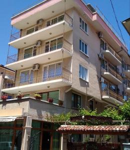 an apartment building with balconies and plants at Family hotel Dramchev in Nesebar