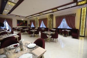 un comedor con mesas, sillas y ventanas en Z Hotel Meknes, en Meknès