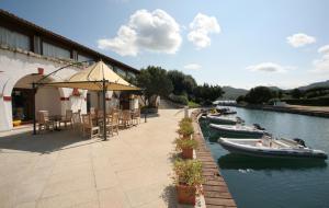 a patio with tables and boats in the water at Hotel Palumbalza Porto Rotondo in Porto Rotondo