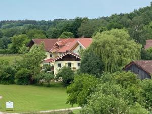una casa grande en medio de un campo verde en Pension am Weberhof nur 20 Autominuten von München, en Ebersberg
