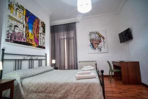 Dormitorio con cama, escritorio y TV en B&B Al Centro en Agrigento