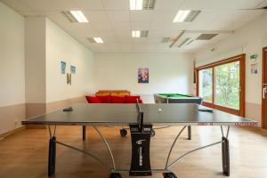 a ping pong table in a room with a couch at LE NID DU BIRDIE, Giez, Proche du lac d’Annecy in Giez