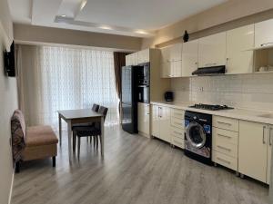 a kitchen with a table and a kitchen with a washing machine at Lux Apartment in Baku