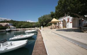 two boats are docked in the water next to a building at Hotel Palumbalza Porto Rotondo in Porto Rotondo