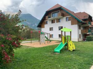 un parque infantil en un patio junto a un edificio en LE NID DU BIRDIE, Giez, Proche du lac d’Annecy, en Giez