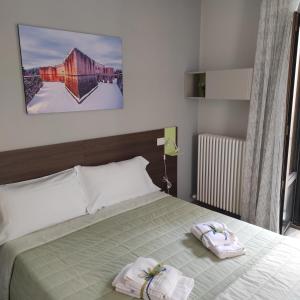 a bedroom with a bed with two towels on it at La Terrazza del Quarto in LʼAquila