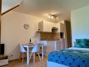 1 dormitorio con 1 cama, mesa y sillas en LE NID DU BIRDIE, Giez, Proche du lac d’Annecy en Giez