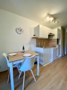 LE NID DU BIRDIE, Giez, Proche du lac d’Annecy في جْيي: مطبخ وغرفة طعام مع طاولة وكراسي خشبية