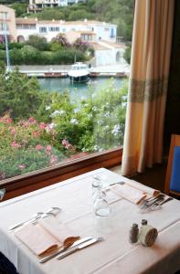a table in a restaurant with a view of a river at Hotel Palumbalza Porto Rotondo in Porto Rotondo