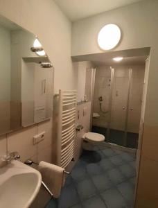 ein Badezimmer mit einem Waschbecken, einem WC und einem Spiegel in der Unterkunft Ferienwohnung "kleine galerie" in Königheim