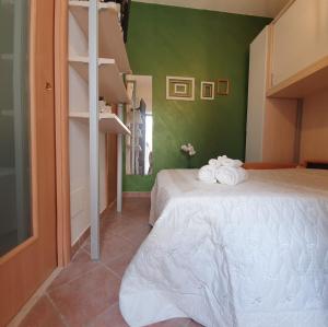 a bedroom with a bed and a green wall at One Love Ortigia in Syracuse
