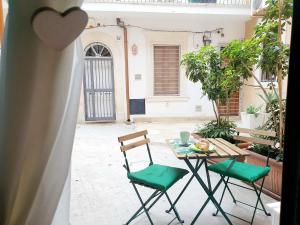 a table and chairs sitting on a courtyard with a table and chairs at One Love Ortigia in Syracuse