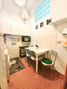 a kitchen with a table and chairs in a kitchen at One Love Ortigia in Syracuse +5 photos