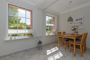 ein Esszimmer mit Tisch und Stühlen und Fenstern in der Unterkunft Ferienwohnungen Becker "Sonne & Meer" und "Strandliebe" in Kühlungsborn