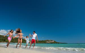 a group of people running on the beach at Hotel Palumbalza Porto Rotondo in Porto Rotondo